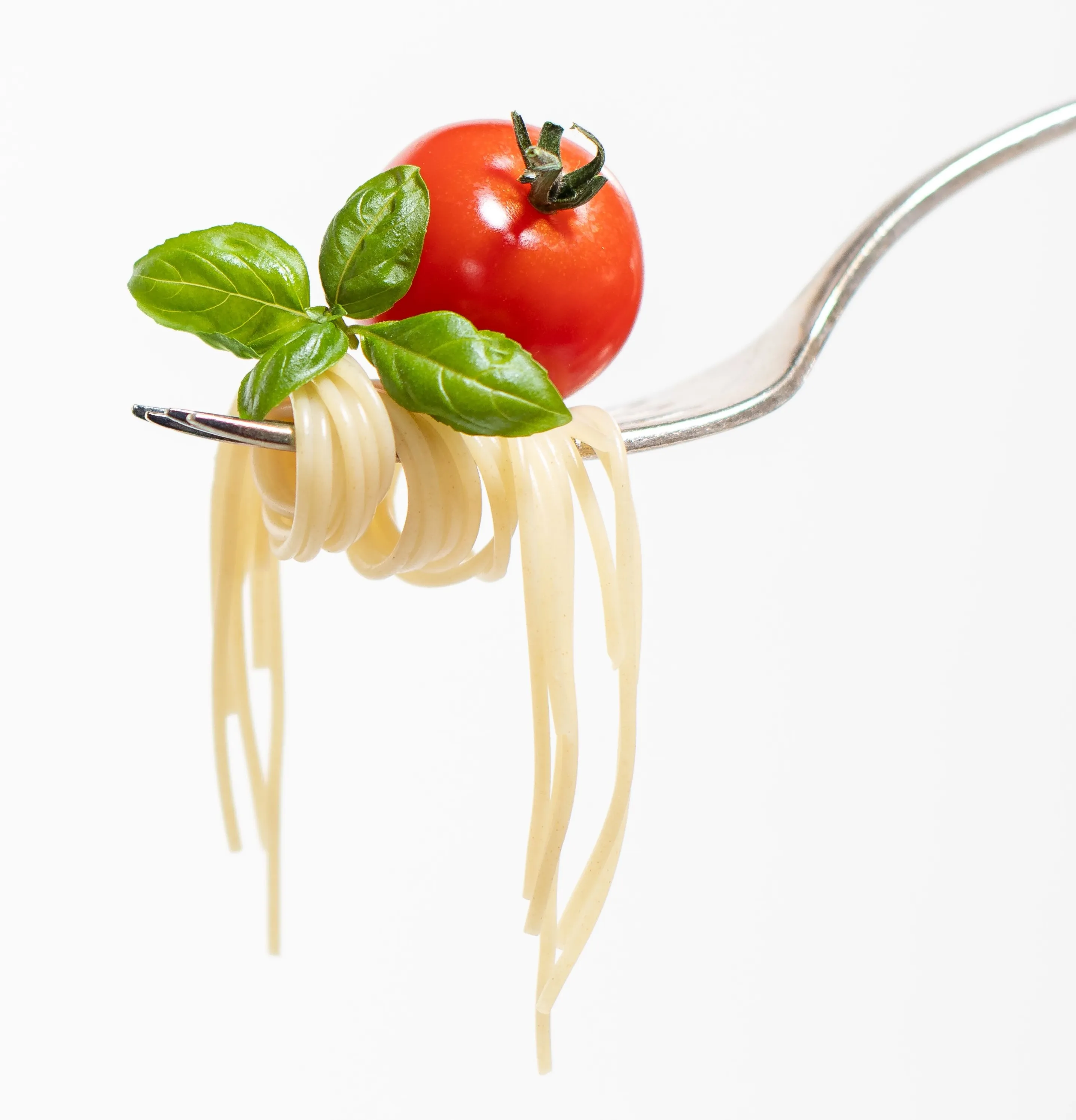 A forkful of spaghetti with tomato and basil